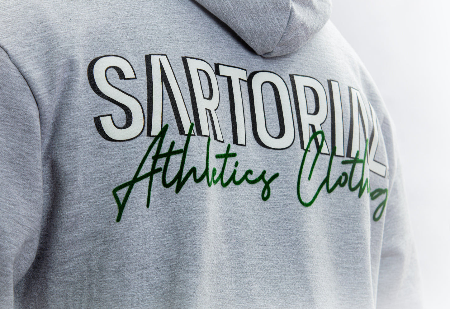 A stylish grey hoodie adorned with the Sartorial Athletics logo in the front using flock technique, exemplifying the brand's commitment to quality and athletic appeal. Elevate your outfit effortlessly with this versatile hoodie, crafted for both sartorial excellence and athletic performance